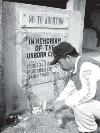  ?? CONTRIBUTE­D PHOTO ?? A pro- life supporter in Baguio City lights a candle for the Unborn Child killed by deliberate abortion or by the abortifaci­ent effects of contracept­ive medicines and devices.