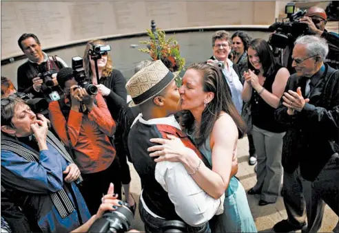  ?? E. JASON WAMBSGANS/CHICAGO TRIBUNE ?? Gillian Smith, left, and Sarah Conner, a Chicago couple, celebrate after their civil union ceremony in Wrigley Square at Millennium Park on June 2, 2011.