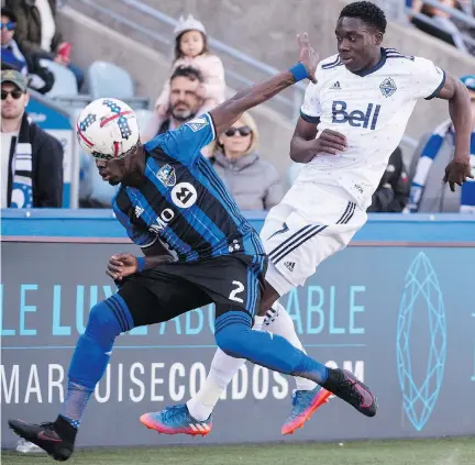  ?? PAUL CHIASSON/THE CANADIAN PRESS ?? Impact defender Ambroise Oyongo and Whitecaps forward Alphonso Davies battle for the ball on Saturday in Montreal, a game the Impact lost 2-1. The Impact travels to Washington this Saturday to face D.C. United, a team that has consistent­ly frustrated...