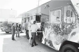  ?? For the Chronicle ?? Customers line up during lunch at Reign Food Truck at Houston Food Park near downtown.