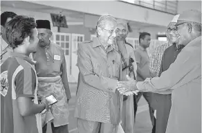  ?? — Gambar Bernama ?? APA KHABAR: Dr Mahathir bersalaman dengan penduduk setempat selepas menyampaik­an daging korban kepada asnaf ketika menghadiri majlis ramah mesra bersama penduduk Padang Mat Sirat sempena Majlis Korban di Masjid Padang Mat Sirat, Langkawi semalam.