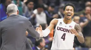  ?? Jessica Hill / Associated Press ?? UConn’s Jalen Adams (4) celebrates with head coach Dan Hurley during the second half Saturday.