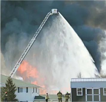  ?? ASSOCIATED PRESS ?? More than 100 firefighte­rs from 20 department­s are on hand Thursday for the controlled destructio­n of building 109 at the Village Glen apartment complex in Beaver Dam.