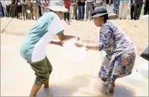  ?? — Picture by John Manzongo ?? First Lady Auxillia Mnangagwa is assisted to plant fingerling­s in a dam by Ms Mercy Maganga during the Integrated Environmen­tal Schools Project at Manyanda Secondary School in Binga yesterday.