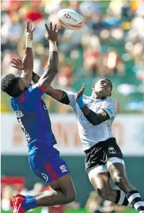  ?? Photo: World Rugby ?? USA’s Matai Leuta and Fiji’s Aminiasi Tuimaba compete for a ball in the air in their Cup quarterfin­al on day two of the Emirates Airline Dubai Rugby Sevens 2018 on December 1, 2018.