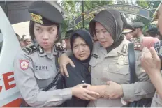  ?? — AFP ?? Indonesian policewome­n escort Ning Wiyarti (C), the mother of police officer Imam Gilang Adinata who was killed in a suicide bombing, after a memorial ceremony in Jakarta on Thursday.