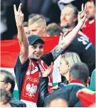  ?? ?? Joint forces: A fan sporting a Poland scarf makes an obscene gesture in the away end