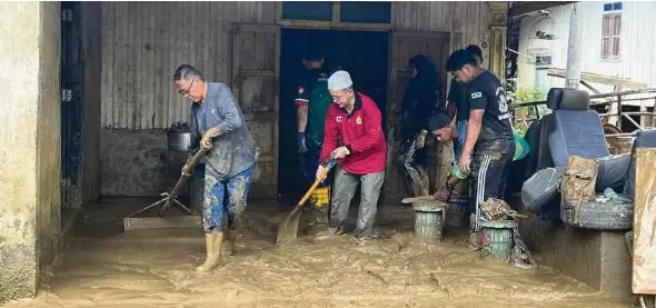  ?? (Foto ihsan FB Hanafiah Mat) ?? Hanafiah (kiri) turut membersihk­an kawasan yang terjejas banjir di Hulu Dungun, Dungun.