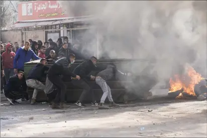  ?? MAJDI MOHAMMED — THE ASSOCIATED PRESS ?? Palestinia­ns clash with Israeli forces following an army raid in the West Bank city of Jenin on Thursday.