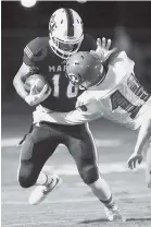  ??  ?? Marion County’s Kane Hale tries to fight off the tackle attempt of Polk’s Caleb Kyle after a catch Friday night.