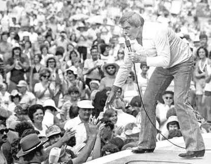  ?? AP FILE ?? Singer Tom T. Hall leans to the edge of the stage at the Jamboree in the Hills to meet fans near St. Clairsvill­e, Ohio, in 1977.