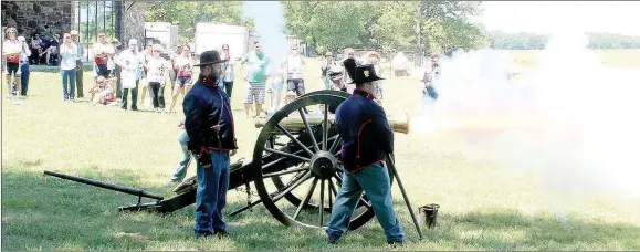  ??  ?? Benton County Volunteers Dean Pippin, left, and Curtis Tilghman fire a Civil War era cannon at Pea Ridge National Military Park during a demonstrat­ion for riders on the Remember the Removal Bike Ride.