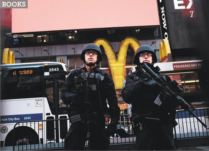  ?? Spencer Platt / Getty Images 2015 ?? New York police officers with high-powered rifles patrol in Times Square in New York after a series of mass shootings and the terrorist attacks in Paris.
