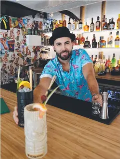  ??  ?? FEELING FRUITY: Flamingos Tiki Bar co-owner Andrew Pare serves up the first cocktails – a Flamingo Sling and a Shipwreck – at the new bar.