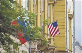  ?? AP PHOTO ?? U.S. and Russian flags hung at the U.S. Embassy in Moscow, Russia. Russia’s Foreign Ministry on Friday ordered a reduction in the number of U.S. diplomats in Russia and said it was closing down a U.S. recreation retreat in response to fresh sanctions.