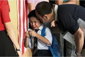  ??  ?? Tears on the first day of school as a father comforts his son who has enrolled for Year One at SK Taman Tun Dr Ismail 1 - YAP CHEE HONG/ The Star.