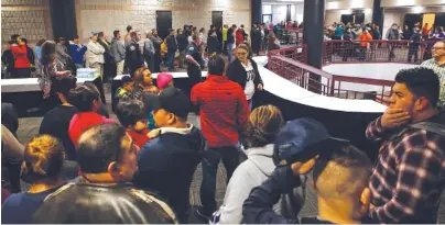  ?? STAFF PHOTO BY C.B. SCHMELTER ?? Family members line up inside the Dalton Convention Center on Wednesday to pick up Dalton (Ga.) High School students. The students were evacuated by bus Wednesday afternoon after social studies teacher Randal Davidson allegedly barricaded himself in a...