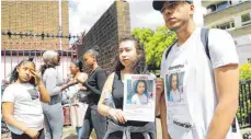  ?? FOTO: AFP ?? Eine junge Frau sucht mit einem Poster nach ihrer Schwester, die nach dem Feuer vermisst wird.