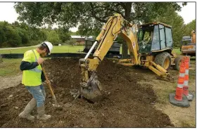  ?? NWA Democrat-Gazette/ANDY SHUPE ?? Chase Goins
(left) uses a shovel Thursday while helping his father, Terry Goins of Goins Enterprise­s in Joplin, Mo., as he uses a backhoe to bury a new water main tap at Smokehouse Trail and Martin Luther King Jr. Boulevard in Fayettevil­le. Goins...