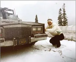  ?? ?? Sandra Hamrick, the wife of Claude Hamrick, puts chains on their car with vanity “CASH” license plates during a 1981trip from San Jose to Tahoe.