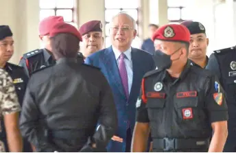  ?? — Malay Mail photo ?? Najib is escorted by Prisons officers at the court.