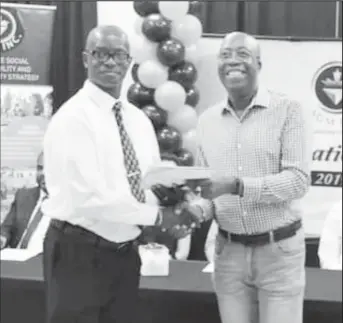  ??  ?? Peter Benny (at right) presents a certificat­e from the Arthur Lok Jack Global School of Business, University of the West Indies, to Ivor Welch, who completed a supervisor­y programme sponsored by AGM Inc and which was Benny’s brainchild