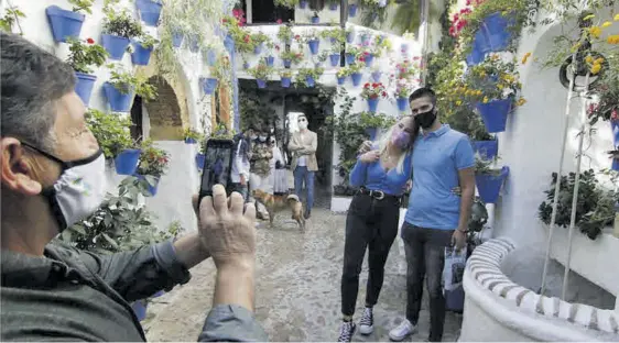  ?? A.J. GONZÁLEZ ?? Un hombre fotografía a una pareja en uno de los patios del barrio de San Basilio el pasado mes de octubre.