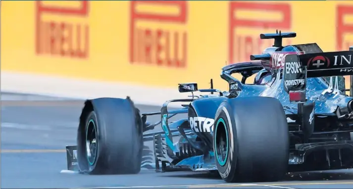  ??  ?? Lewis Hamilton cruza la meta del GP de Gran Bretaña, ayer en el circuito de Silverston­e, con una rueda de su Mercedes W11 en el suelo tras sufrir un pinchazo en la última vuelta.