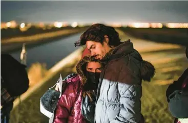  ?? GREGORY BULL/AP ?? A couple from Cuba wait to be processed to seek asylum after crossing the border Jan. 6 into the United States, near Yuma, Arizona. An undergroun­d market has emerged for migrants seeking U.S. sponsors.