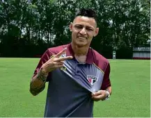  ?? Érico Leonan/saopaulofc.net ?? Atacante Neilton veste a camisa do São Paulo após acerto