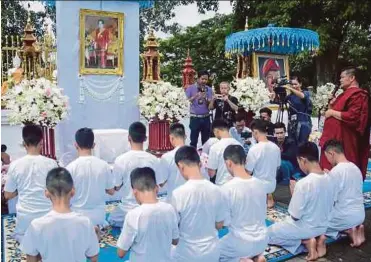  ?? EPA PIC ?? Members of the Wild Boars football team, who were rescued from Tham Luang cave, offering prayers next to Buddhist monks at Wat Phra Thart Doi Wao temple in Mae Sai district, Chiang Rai province, yesterday.