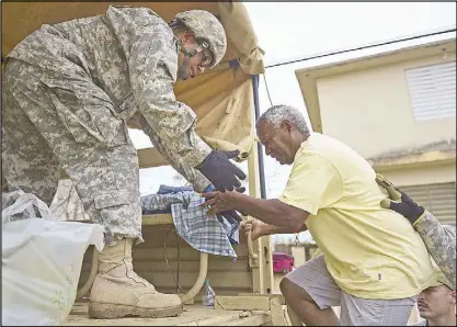  ?? AP ?? National Guard personnel evacuate Toa Ville resident Luis Alberto Martinez after Hurricane Maria dumped heavy rains over Toa Baja, Puerto Rico on Sept. 22.