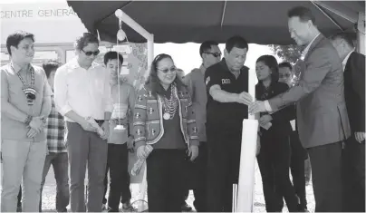  ?? PCOO ?? President Rodrigo Duterte (2nd from right) is assisted by Chinese Ambassador to the Philippine­s Zhao Jianhua (rightmost) as he places the blueprint for a multi-million Drug Abuse Treatment and Rehabilita­tion Center inside a time capsule during the...