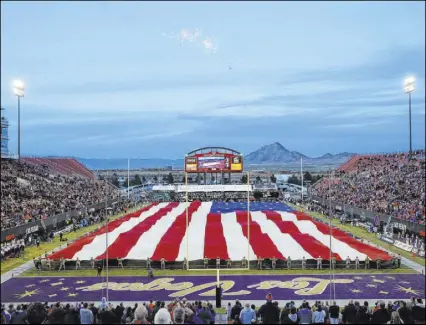  ?? Steve Marcus The Associated Press ?? Nellis Air Force Base airmen unfurl a 100-yard-long American flag during ceremonies prior to kickoff for the Las Vegas Bowl between Boise State and Washington on Dec. 21 at Sam Boyd Stadium.