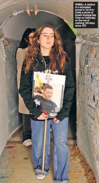  ?? ?? VIGIL: A relative in a simulated tunnel in Tel Aviv holds a photo of Israeli hostage Itay Chen on Saturday, on the eve of marking 100 days since 10/7.