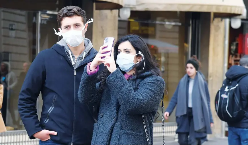  ??  ?? ↑
Tourists with protective mask visit Florence as Tuscany reported its first two cases of COVID-19.
Agence France-presse