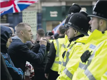  ??  OLI SCARFF/AFP/GETTY IMAGES FILES ?? Protesters from the U.K. branch of the German group PEGIDA, which opposes what it calls the ‘Islamizati­on’ of Europe, face off with police last weekend in Newcastle, England. A new Quebec branch of the group is set to hold its first rally on March 28...