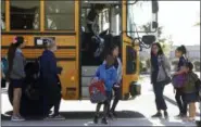  ?? ROSS D. FRANKLIN — THE ASSOCIATED PRESS ?? Students exit a school bus as they return to Tuscano Elementary School for class Thursday in Phoenix. After an all night legislativ­e budget session the legislatur­e passed the new education spending portion of the budget and Republican Gov. Doug Ducey signed that part of the budget.