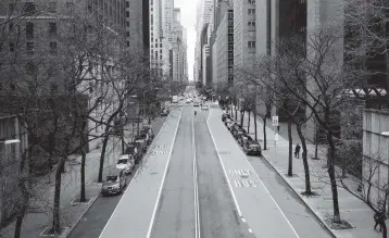  ?? SPENCER PLATT Getty Images ?? A street stands empty in Manhattan on Monday. Officials said the J&J vaccine will help New York City inoculate millions more people by summer, including through door-to-door vaccinatio­ns of homebound senior citizens.