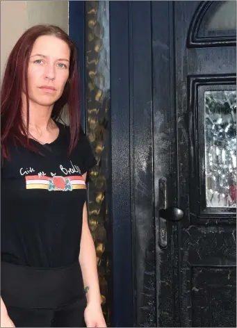  ?? Photos by Michelle Cooper Galvin ?? Michelle O’Brien showing the scorched exterior of her front door in Ballyspill­ane, Killarney, following last week’s horrific petrol-bombing incident and, right, the scene outside the family home as the garda investigat­ion got underway.