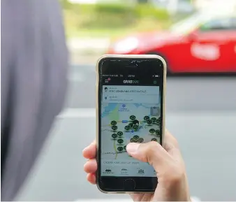  ?? MOHD FYROL/AFP/GETTY IMAGES ?? Toyota Motor is exploring new revenue models through its investment in Grab, South Asia’s key ride-hailing operator, as it races with other carmakers to become big players in ride-sharing.