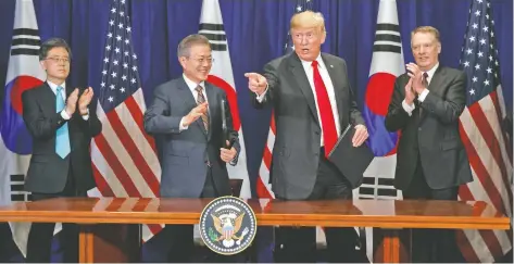  ??  ?? El presidente de Corea del Sur, Moon Jae-in (segundo izq.) y el mandatario estadounid­ense, Donald Trump, en la ceremonia de firma de un acuerdo comercial.