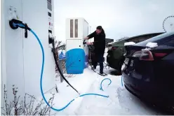  ?? SERGEI GRITS/THE ASSOCIATED PRESS ?? A driver charges an electric car last month at a parking lot in Tallinn, Estonia. Many electric vehicle batteries lose power when it’s very cold.