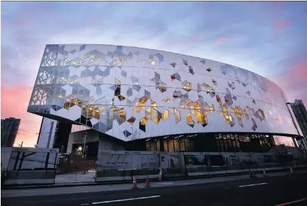  ?? PHOTOS: LEAH HENNEL ?? The sun rises over the Central Library that boasts a blue and white “curtain wall” exterior made of 460 hexagonal glass panels.