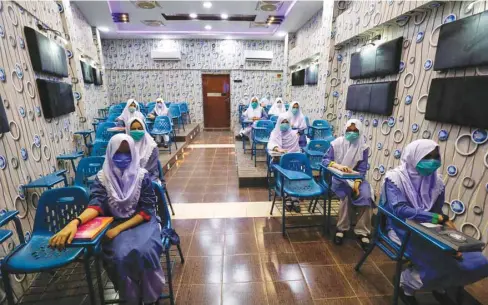  ??  ?? Students keep a safe distance while attending an audio-visual class, as schools reopen amid the coronaviru­s pandemic in Karachi, Pakistan.