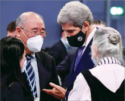  ?? BEN STANSALL / AFP ?? Xie Zhenhua (left), China’s special climate envoy, speaks with John Kerry, the US’ special climate envoy, before a meeting at the COP26 UN Climate Change Conference in Glasgow on Nov 13.