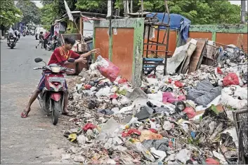  ?? DITA ALANGKARA — THE ASSOCIATED PRESS ?? A man adds a bag of waste to an open garbage dump in Jakarta, Indonesia, on Tuesday. Jakarta is home to about 10 million people, with three times that number living in the greater metropolit­an area.