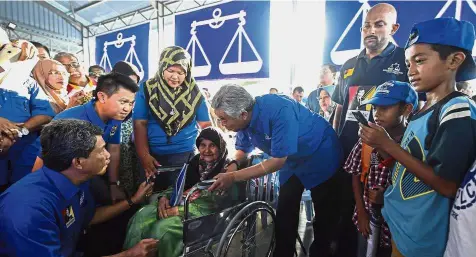  ??  ?? Personal touch: Dr Ahmad Zahid talking to Azizah Abdul Karim, 79, during a meet-the-people session at Taman Dusun Nyiur in Seremban. With him are Mentri Besar Datuk Seri Mohamad Hasan and Chong. — Bernama