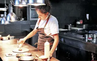  ??  ?? La jefa de cocina, preparando uno de los platos con papas o patatas amazónicas.