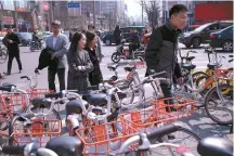  ?? AFP-Yonhap ?? People walk among shared bicycles on a street in Beijing, March 28.